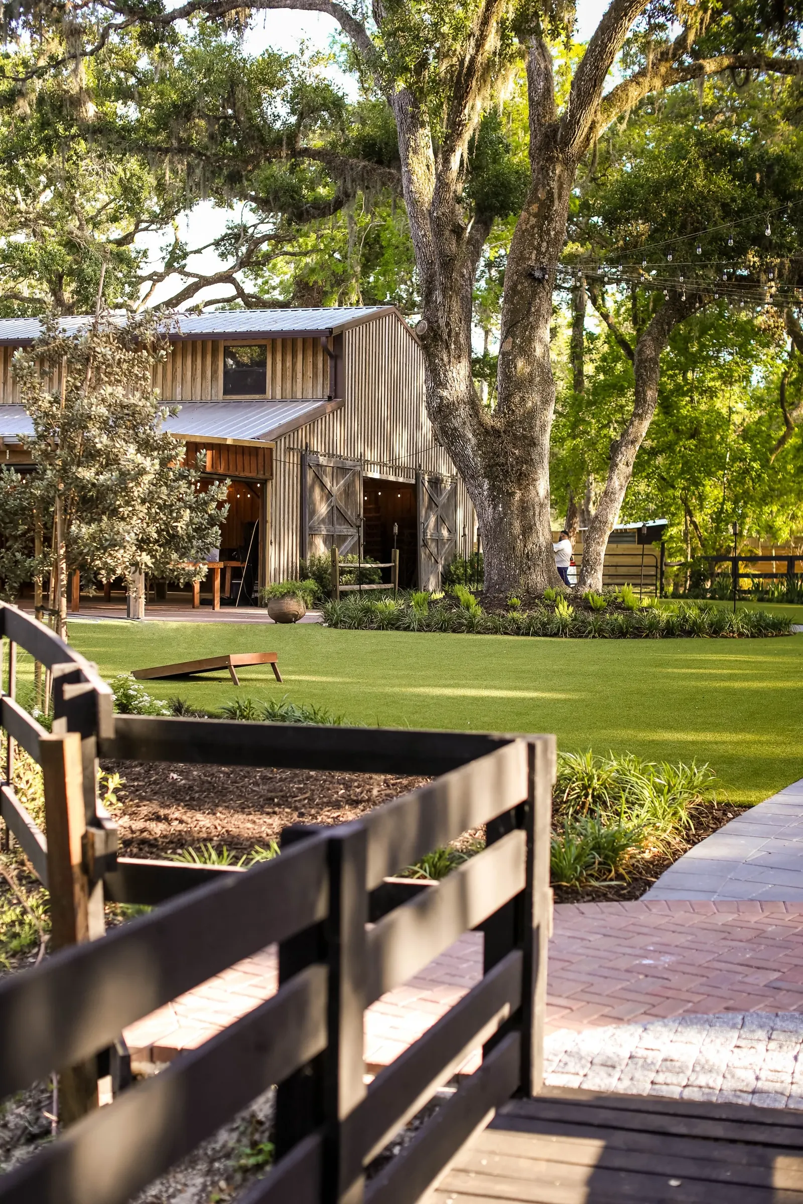 The rustic barn beside a wooden bridge and lawn
