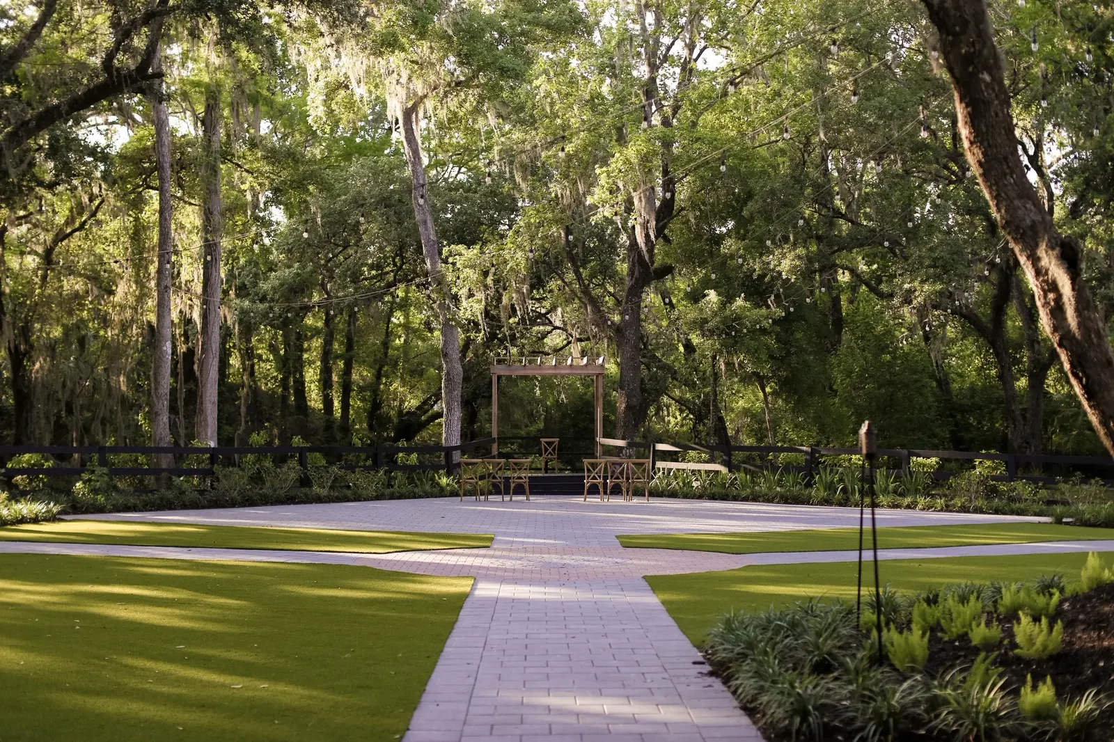 A paved path through a lawn under live oaks at Southern Streams Ranch