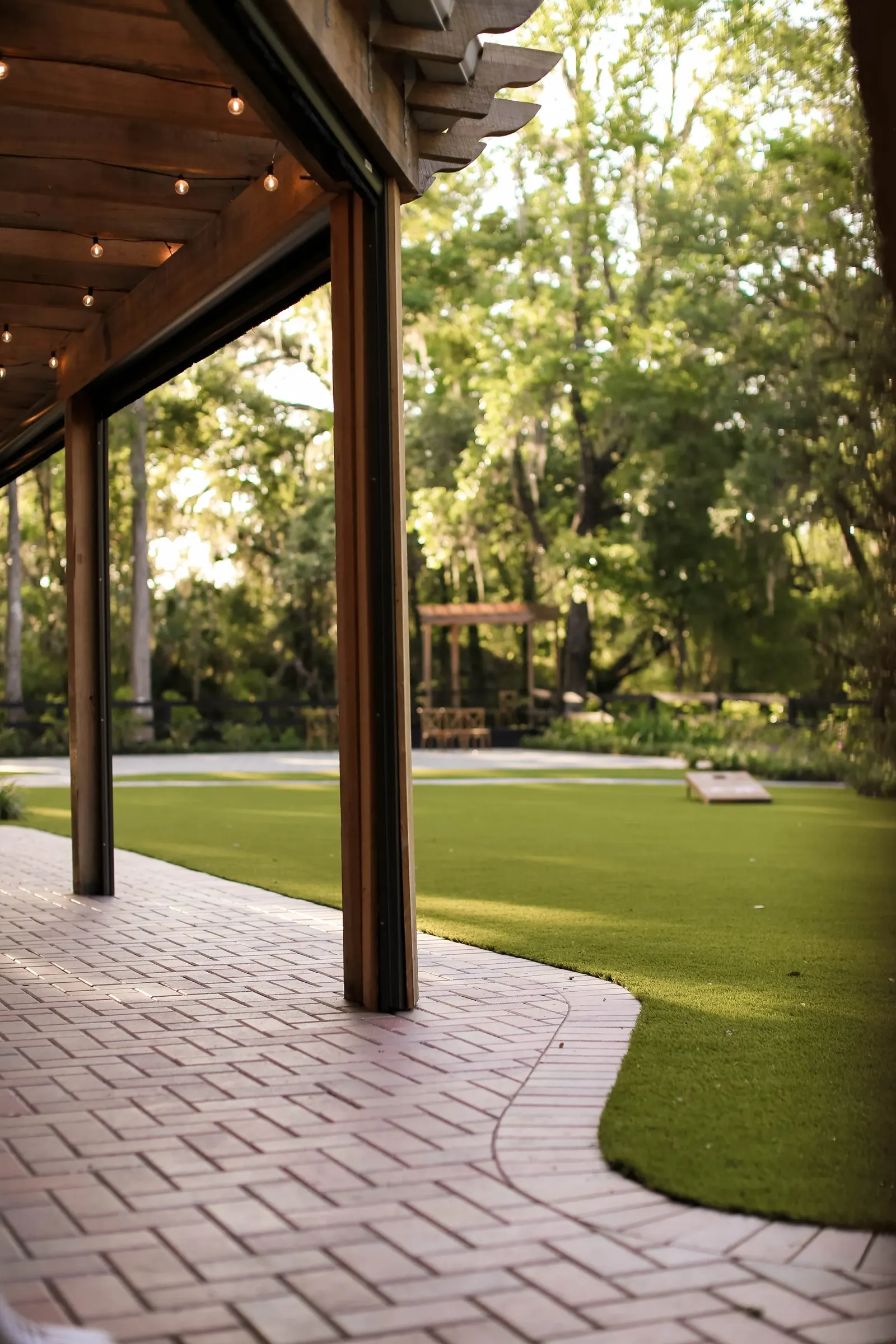 The covered pergola patio with brick-style pavers
